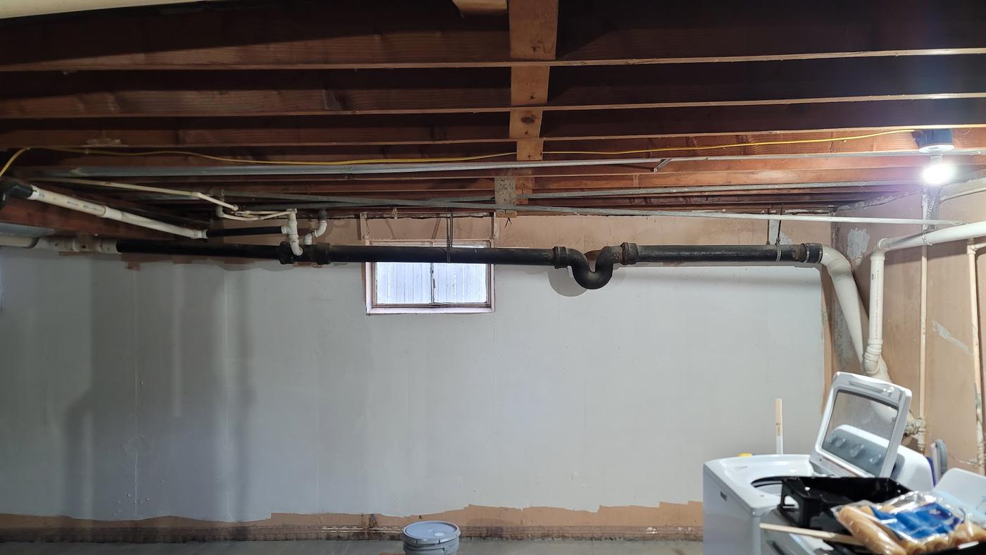 Overhead pipework running through a basement.
